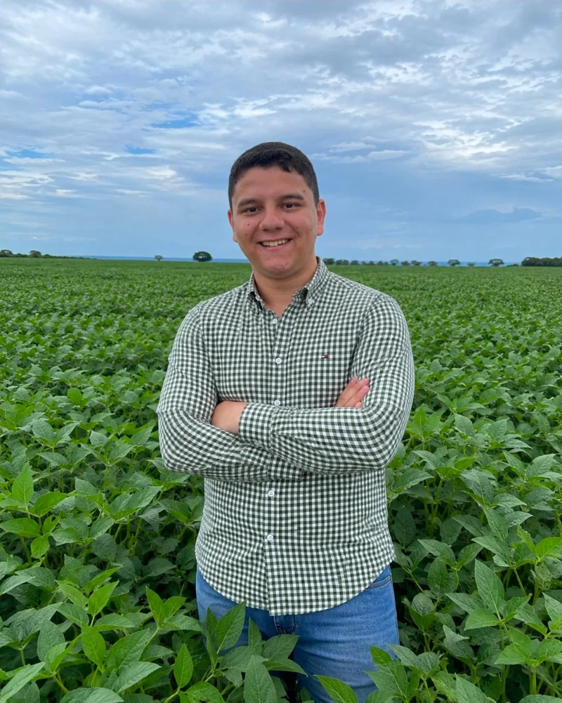 Eduardo Mendes, de braços cruzados e camisa xadrez, em uma lavoura de soja